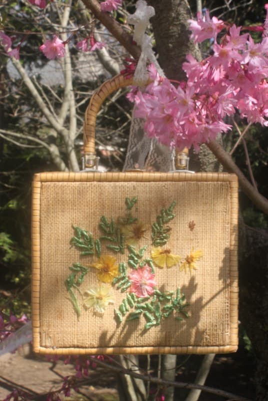 Round wicker basket purse hanging from a branch